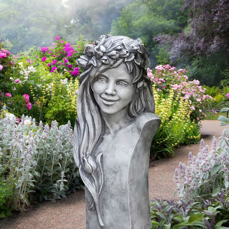 Sculpture de jardin d'une fille souriante avec une couronne de fleurs, entourée de fleurs colorées
