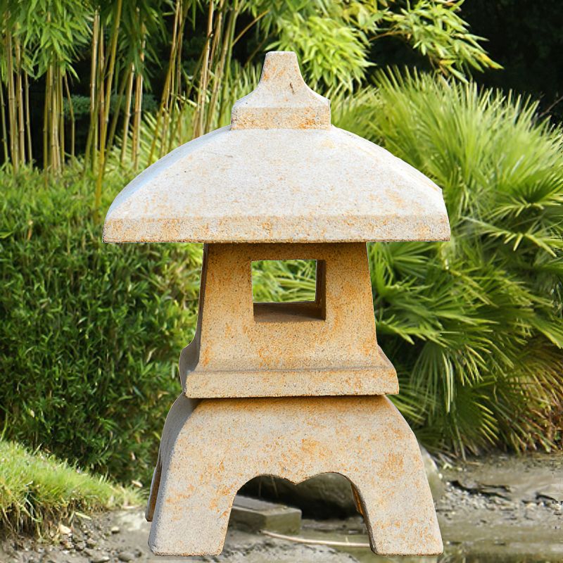 Lanterne japonaise en pierre dans un jardin vert avec des bambous en arrière-plan