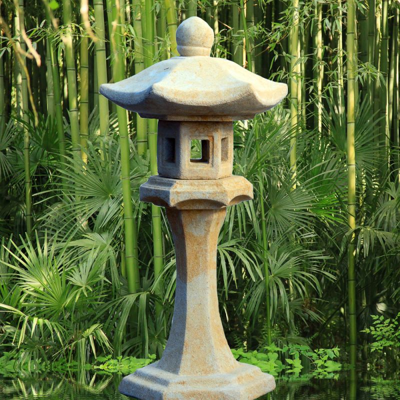 Lantern en pierre décorative dans un jardin vert avec des bambous