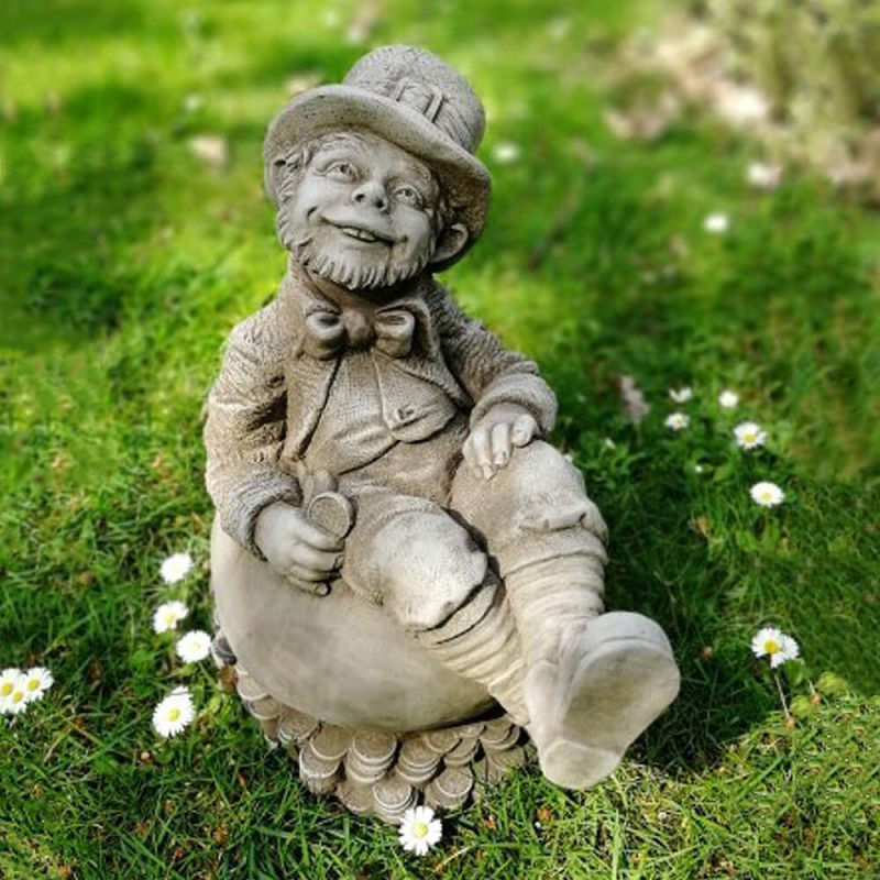 Décoration de jardin amusante : figure en pierre assise sur une pelouse avec des fleurs