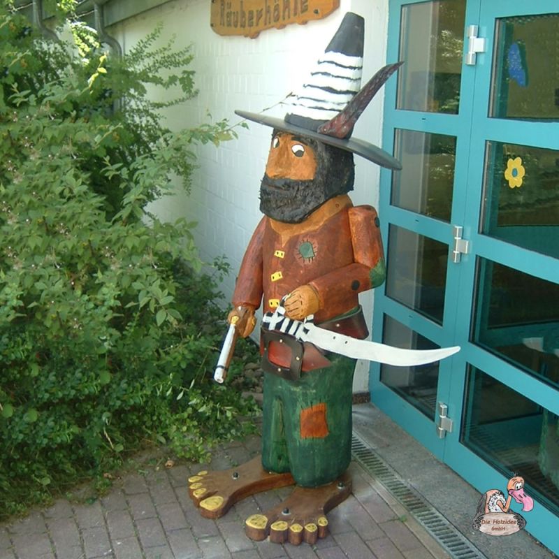Décoration de jardin sculptée à la main représentant une sorcière devant une plante et une porte vitrée
