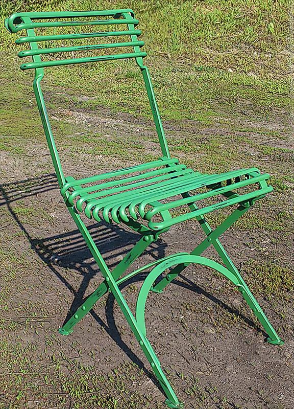 Sedia pieghevole in metallo verde su prato, decorazione da giardino