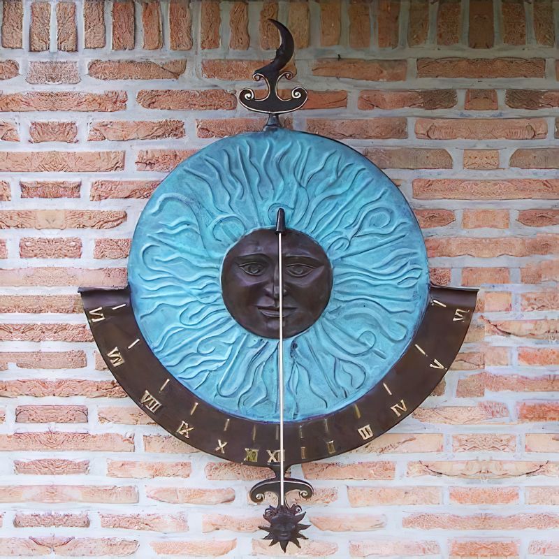 Cadran solaire mural en métal avec soleil bleu et fond en cuivre sur mur en briques