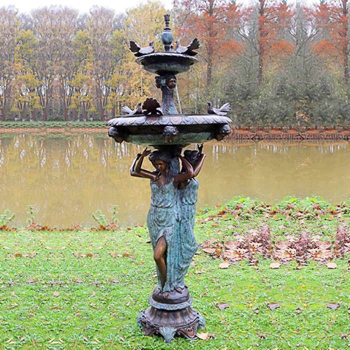 Fontaine de jardin ancienne avec figures féminines et oiseaux, entourée d'un paysage d'automne au bord d'un étang