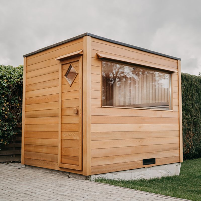 Casetta da giardino compatta con grande finestra e porta in legno nel giardino