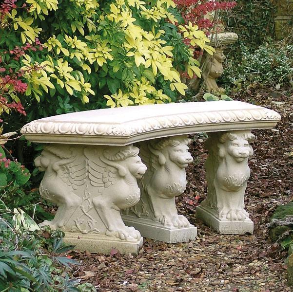 Panchina decorativa in pietra con piedi scolpiti a forma di leone in un giardino autunnale