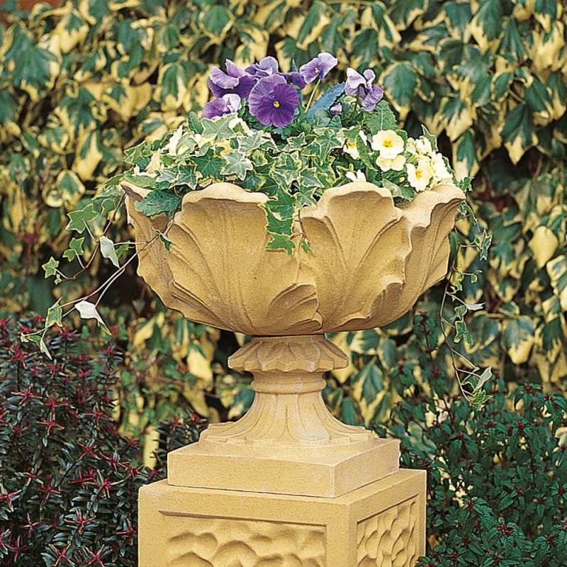 Vaso decorativo in pietra con fiori colorati nel giardino