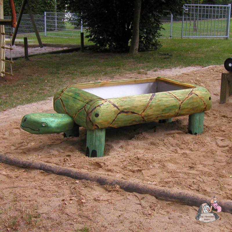 Grüner Sandkasten für Kinder in Form einer Schildkröte im Garten