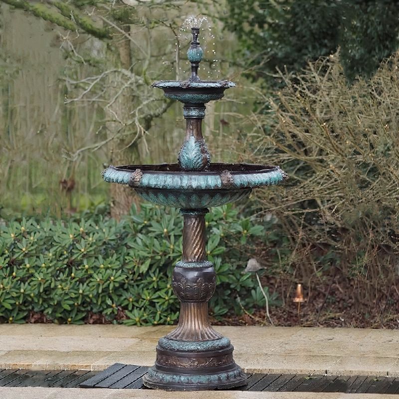 Gros plan d'une fontaine de jardin décorative en métal à plusieurs niveaux dans un jardin