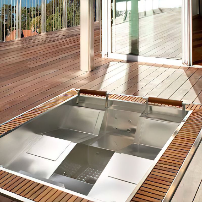 Bain à remous moderne encastré en acier inoxydable avec décor en bois sur une terrasse de jardin