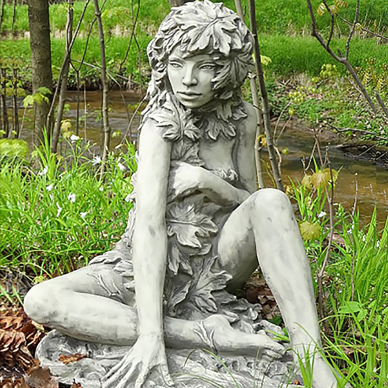 Scultura dettagliata in pietra di una giovane donna in giardino vicino all'acqua