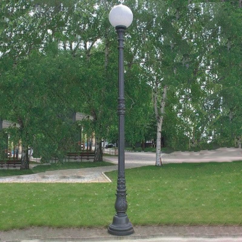 Lampione da giardino nero con globo bianco su prato verde e alberi sullo sfondo