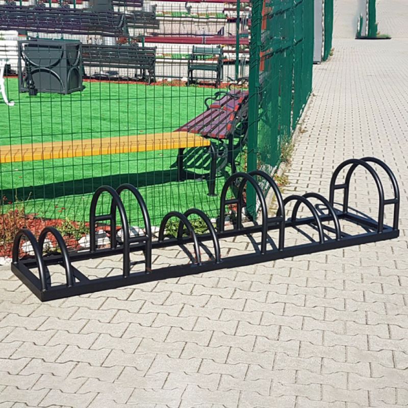 Support à vélos noir en métal sur sol pavé dans un espace jardin
