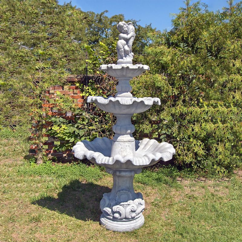 Fontana da giardino bianca a tre livelli in pietra in un giardino verde