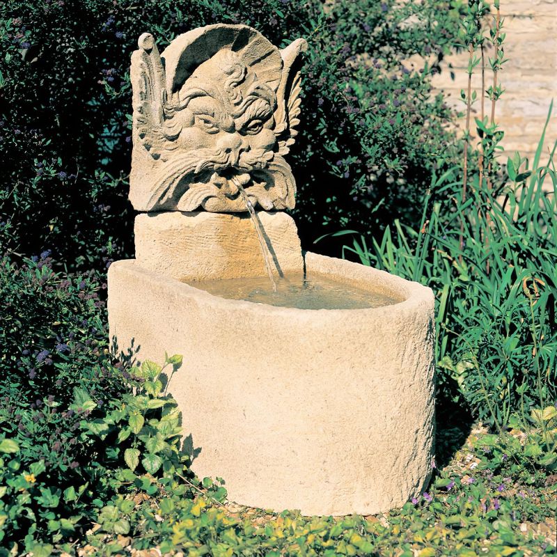 Fontana decorativa in pietra da giardino con flusso d'acqua da una scultura a volto