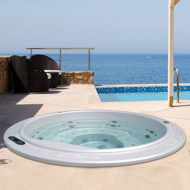 Vasca idromassaggio bianca all'aperto accanto a piscina e mare in giardino moderno