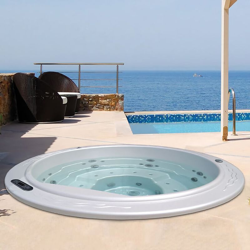 Moderna vasca idromassaggio rotonda sulla terrazza con vista sul mare e mobili da giardino