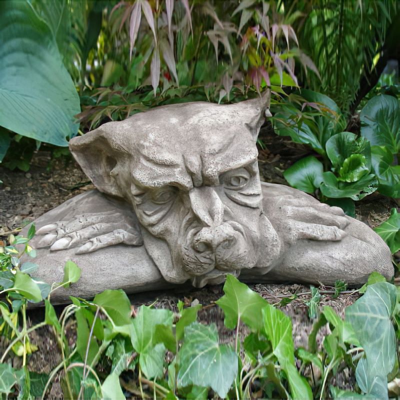 Décoration de jardin en pierre représentant un animal stylisé sur un lit de feuilles vertes