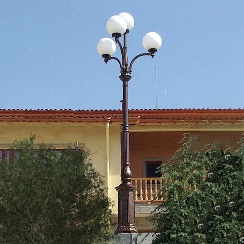 Elegante lampada da giardino con globi luminosi davanti a una casa con balcone