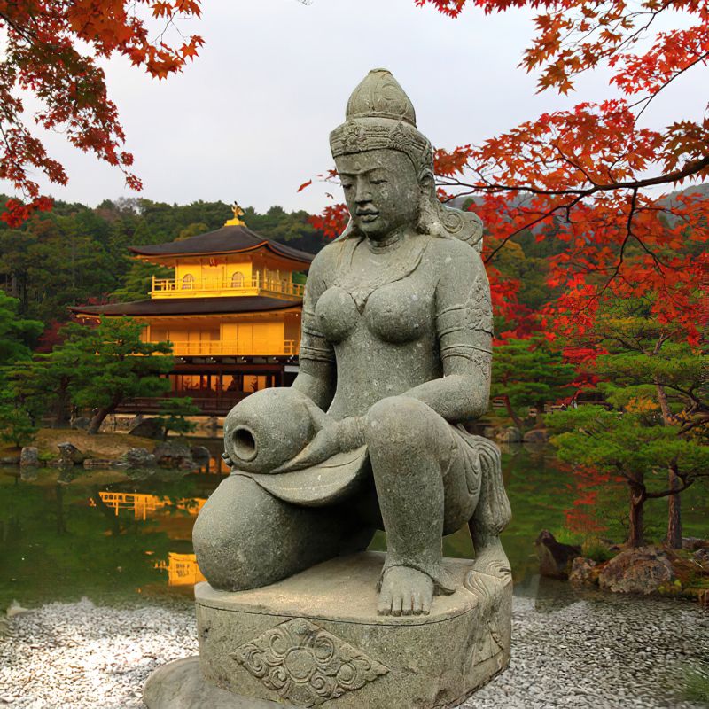 Decorazione da giardino: statua di pietra dettagliata di una donna inginocchiata con un vaso davanti a alberi autunnali e un tempio