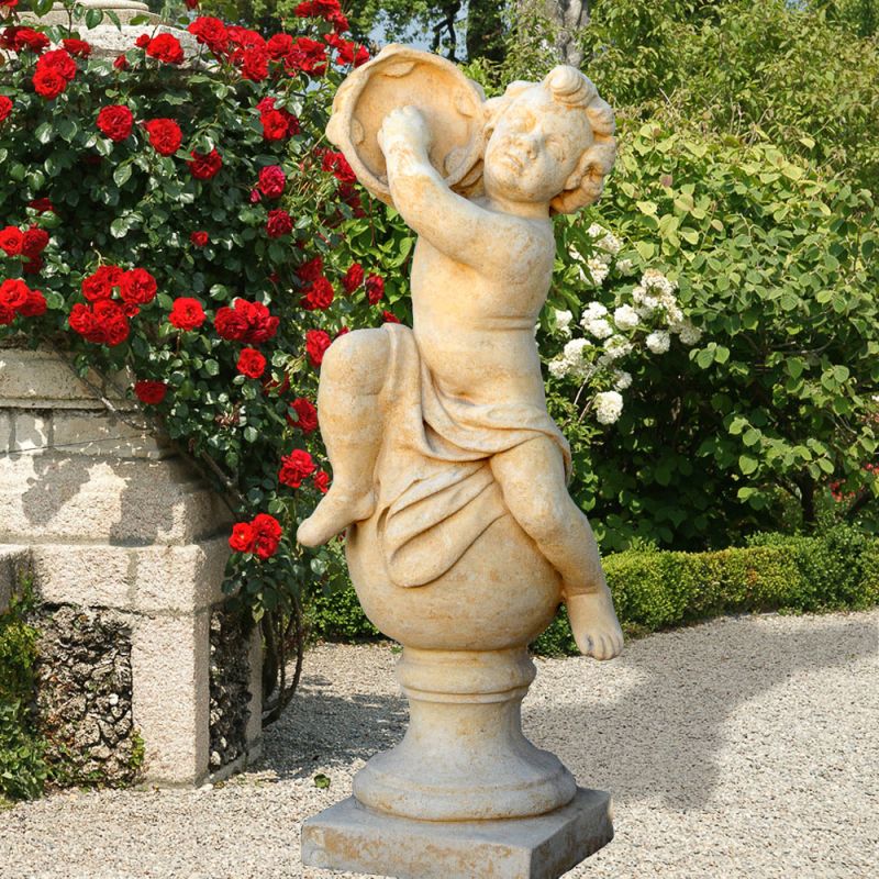 Décoration de jardin en pierre : statue d'un enfant dans un jardin avec des roses
