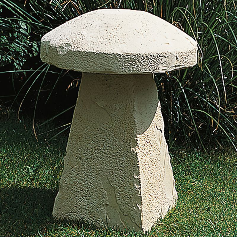 Figurine de champignon beige en pierre décorant un jardin sur de l'herbe verte