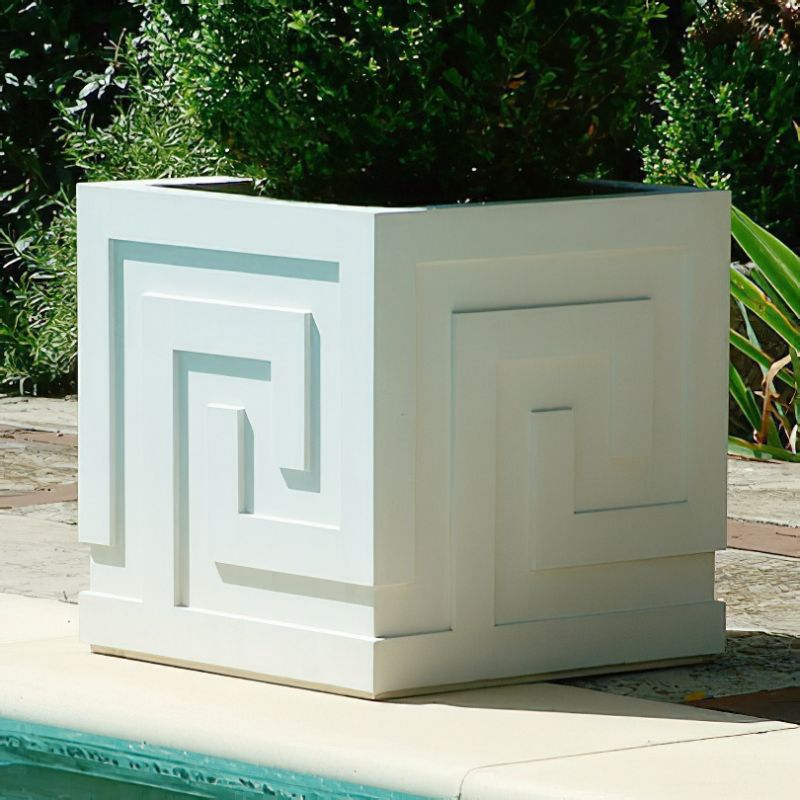 Pot de fleurs blanc avec motif en labyrinthe dans le jardin près de la piscine