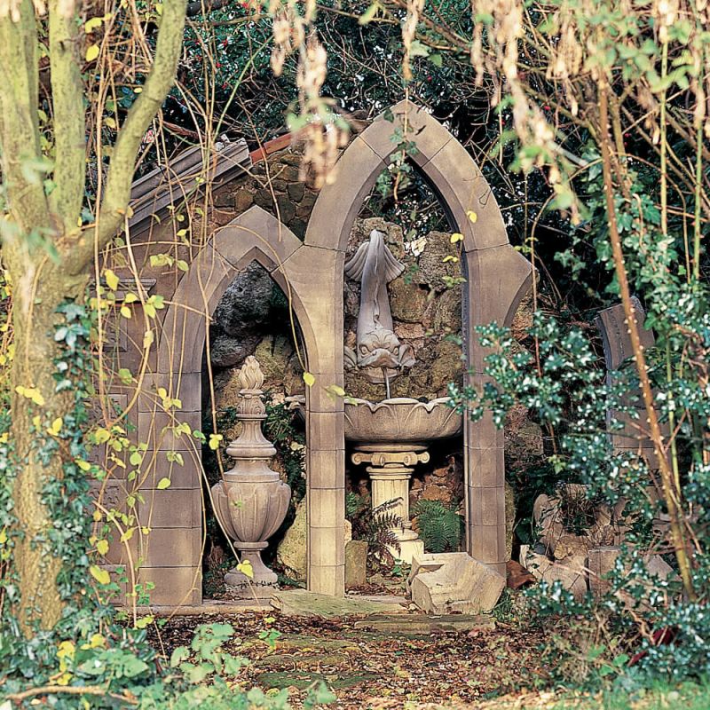 Statue de jardin détaillée dans un cadre gothique entourée de végétation