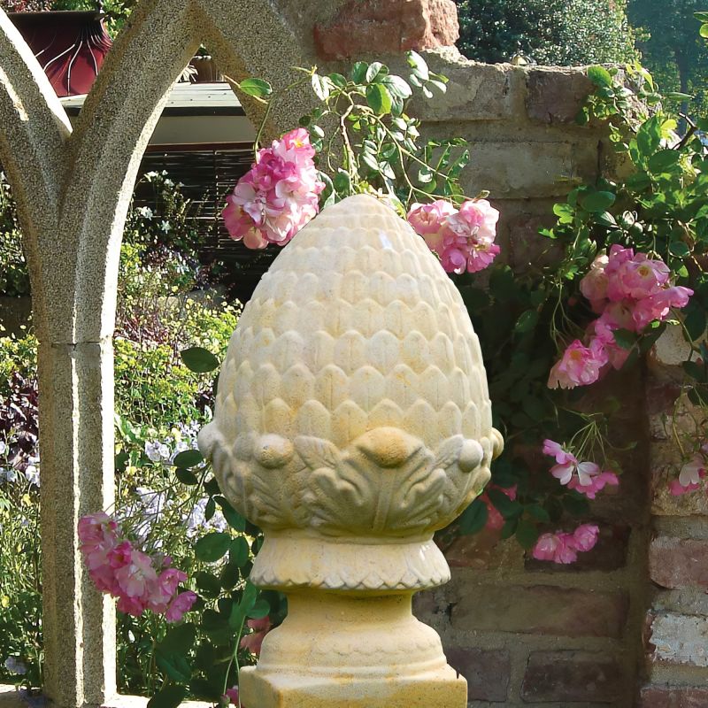 Ornamento di pietra a forma di frutto con rose nel giardino