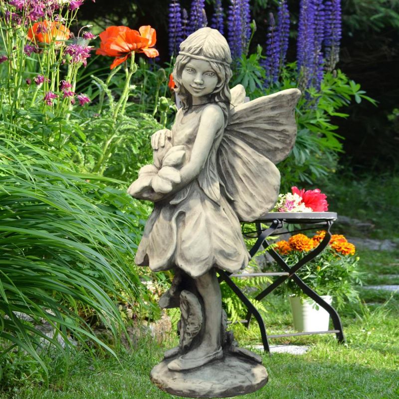 Sculpture en pierre de fée avec des fleurs en arrière-plan dans un jardin