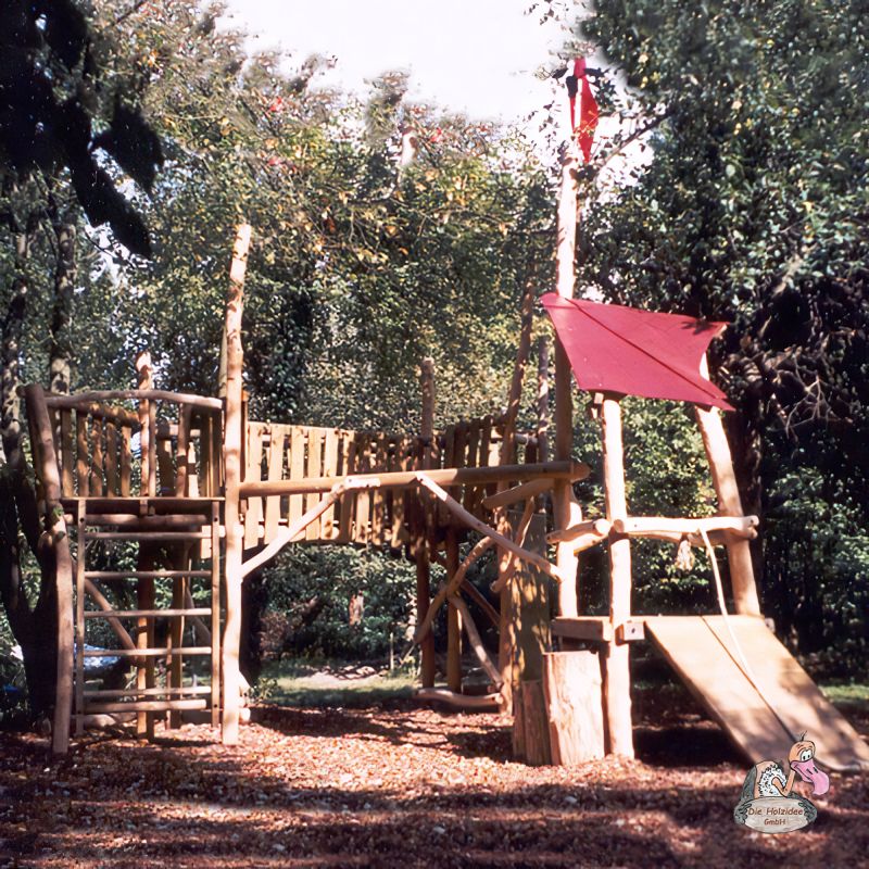 Holzspielplatz mit Rutsche und Kletternetzen im Garten, umgeben von Bäumen