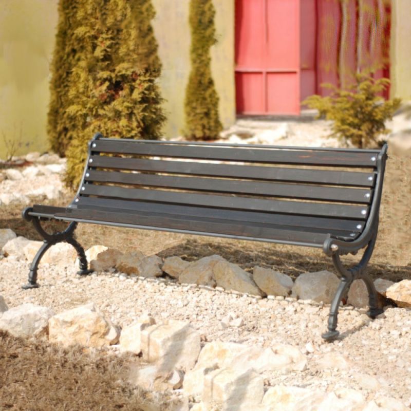 Robusta panchina da giardino nera su sentiero di ghiaia in giardino soleggiato con decorazioni in pietra