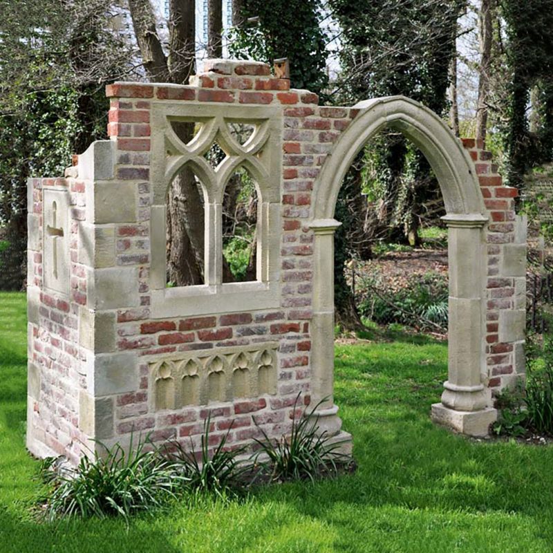 Sculpture décorative de jardin en brique avec fenêtre ogivale et arche sur pelouse verte