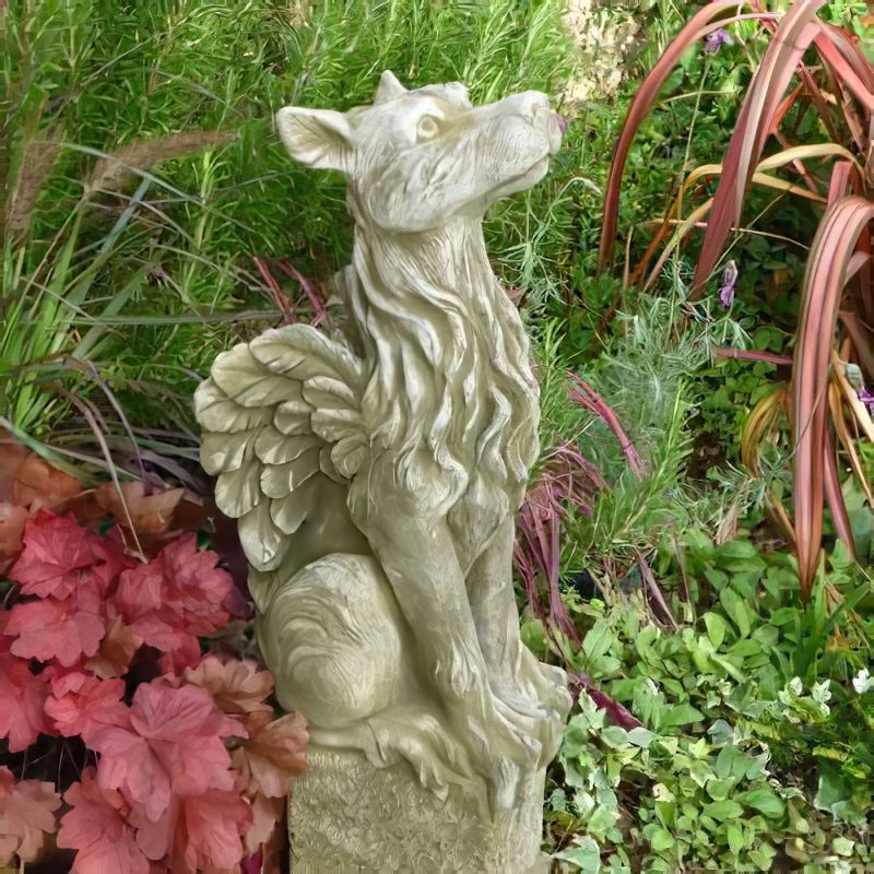 Décoration de jardin d'une créature ailée en pierre dans un jardin vert avec des plantes