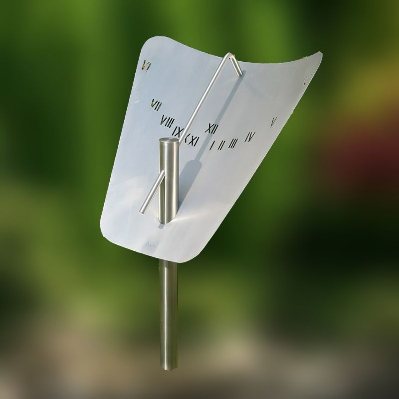 Cadran solaire argenté avec cadran incurvé dans un jardin