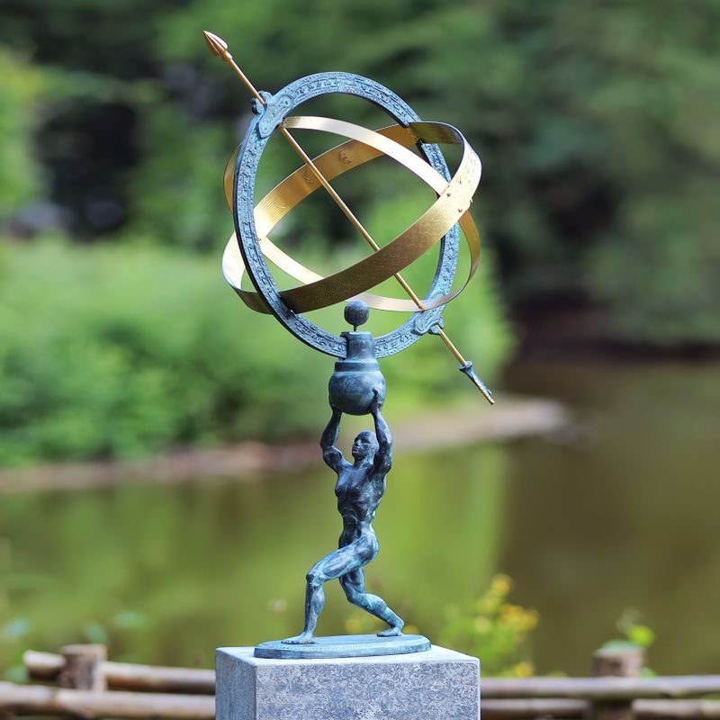 Cadran solaire en métal avec statue d'Atlas dans un jardin sur un socle en pierre