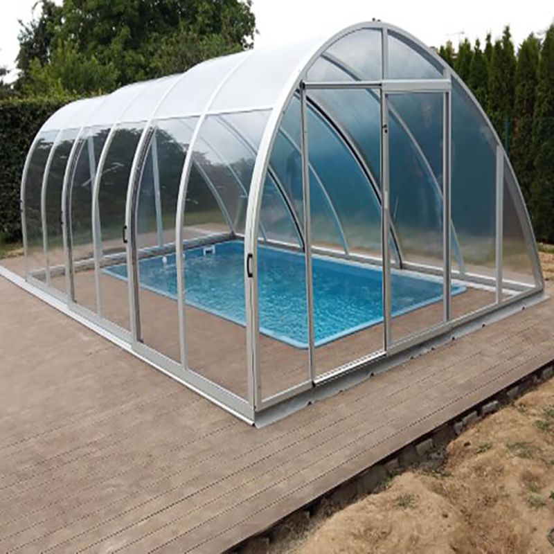 Piscine moderne avec couverture en aluminium et verre dans le jardin