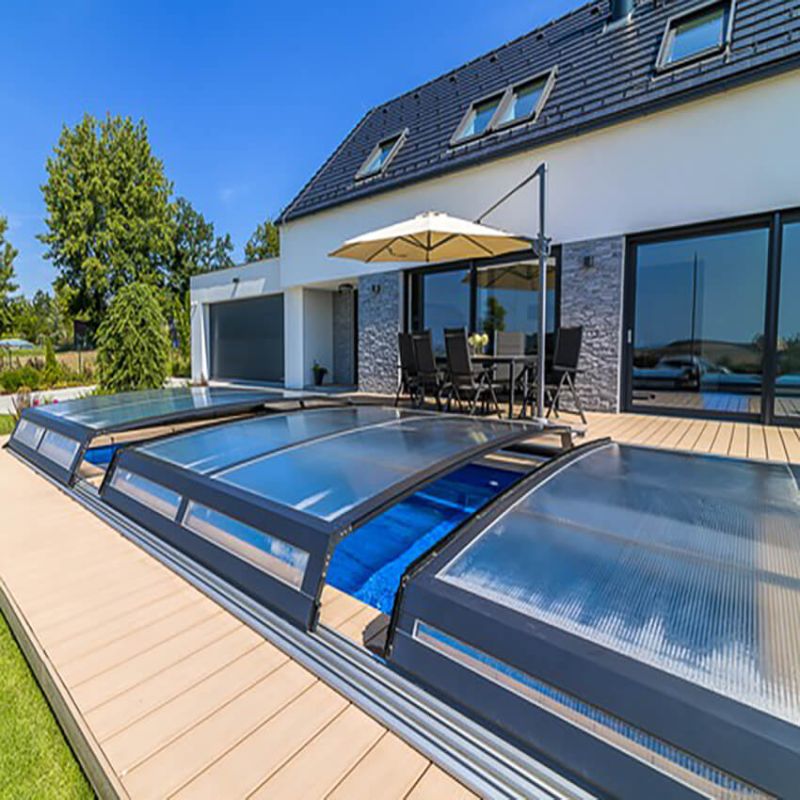 Jardin moderne avec piscine rectangulaire et couverture transparente sur une terrasse devant une maison