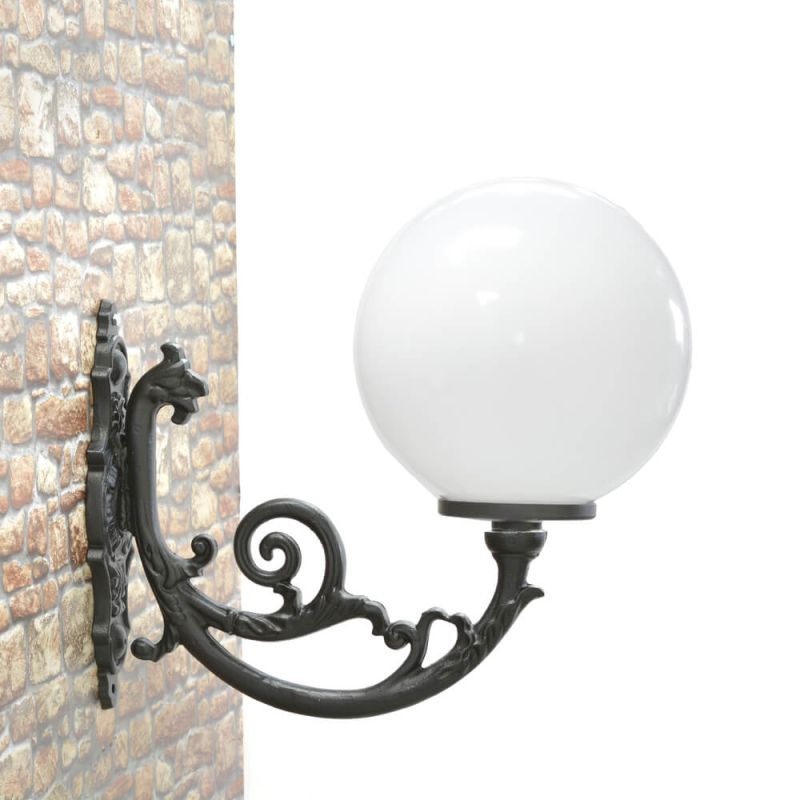 Elegante applique da parete in metallo nero con paralume sferico in vetro bianco fissata a un muro in pietra