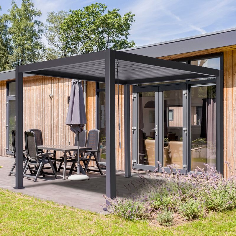 Pergola noire sur une terrasse avec meubles de jardin devant une maison moderne