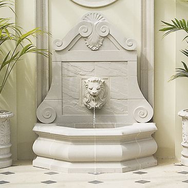Elegante fontana da giardino bianca con acqua corrente e scultura di testa di leone sulla parete