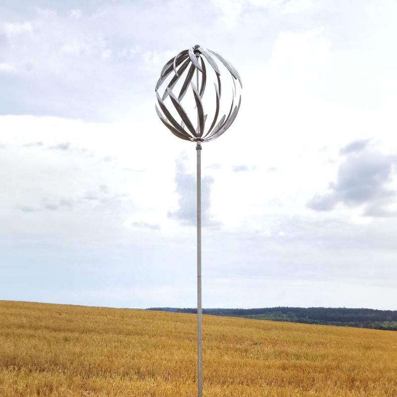 Mobile elegante in acciaio inox in un campo con cielo blu e poche nuvole