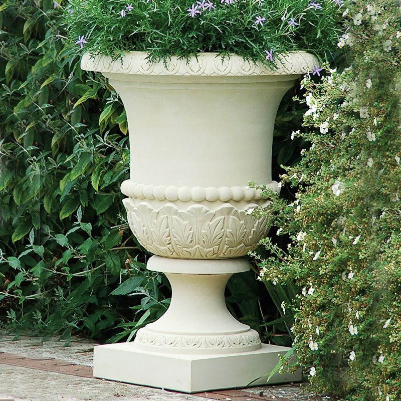 Grande vaso decorato in pietra con fiori nel giardino