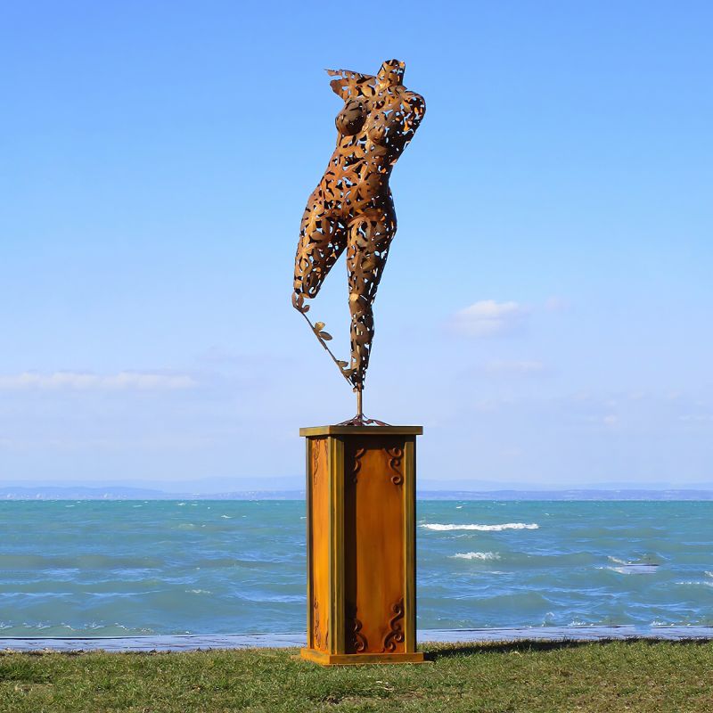 Sculpture métallique abstraite sur un socle au bord de la mer dans un jardin